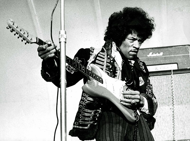 Image of Jimi Hendrix playing an electric guitar upside down to account for his left-handedness.